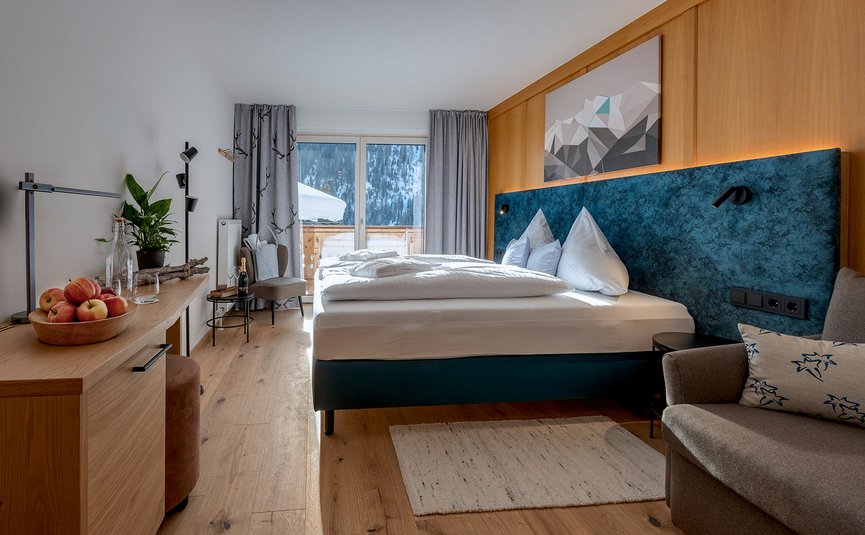 DAS UNTERRAIN lifestyle hotel **** © Armin Kleinlercher Modernes Hotelzimmer mit großem Bett, Holzverkleidung und Bergblick