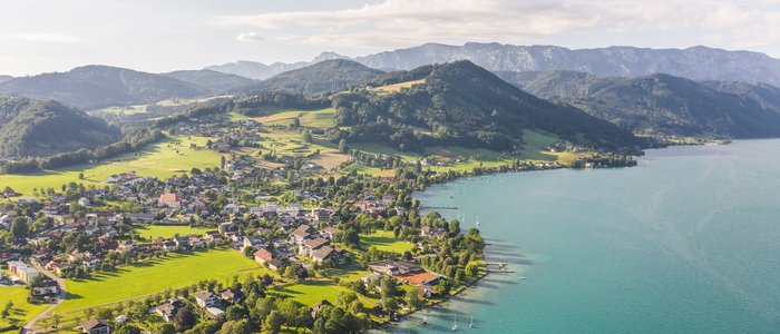 Gast-Hof-Laden Schneeweiss *** © TVB Attersee Attergau - Moritz Ablinger Luftaufnahme eines Sees mit Dorf und Bergen im Hintergrund