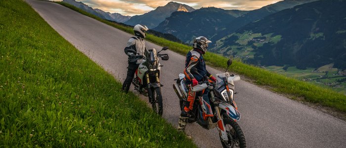 Zillertal – Gerlos Alpenstraße © Moppetfoto.de Zwei Motorradfahrer auf bergiger Straße mit Blick auf Tal und Berge bei Sonnenuntergang