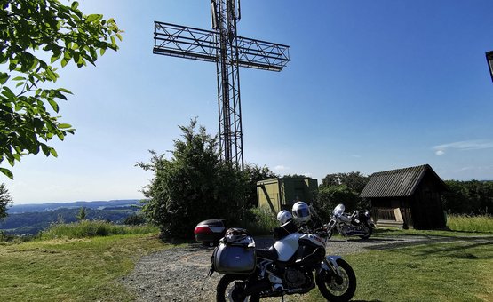 Motorradurlaub im Burgenland © Leberzipf Didi Motorräder vor einem großen metallischen Kreuz auf einem Hügel