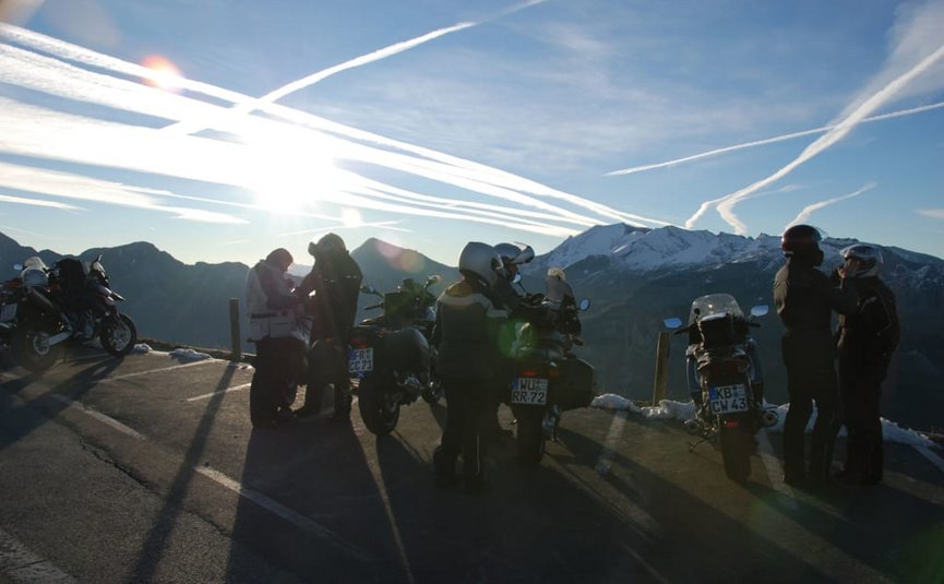 BIKEGENUSS "Großglockner" Motorradfahrer mit Bergen im Hintergrund bei Sonnenuntergang