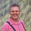 Motorradurlaub in Kärnten © qSTALL.org Mann mit rotem Hemd und Lederhose lächelnd im Freien