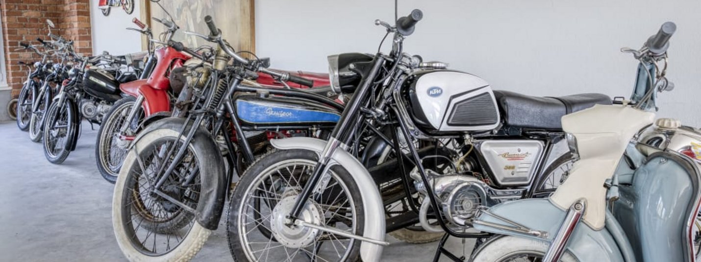 Motorrad & Vespa Weekend Reihe verschiedener alter Motorräder in einer Halle
