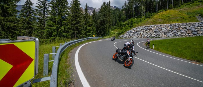 Hochkönig © Moppetfoto.de Motorradfahrer auf kurviger Bergstraße mit Fahrradfahrer und Wald