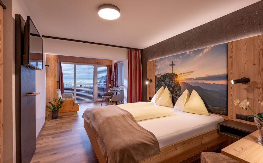 Gemütliches Hotelzimmer mit Doppelbett und Bergblick als Wandbild