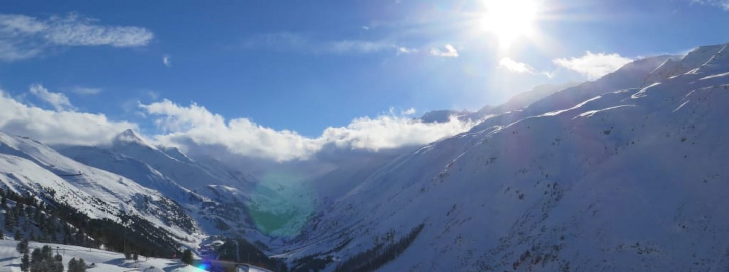 Skiweltcup 4-Tg. Sonniger Tag in einem schneebedeckten Tal mit Bergen und Bäumen