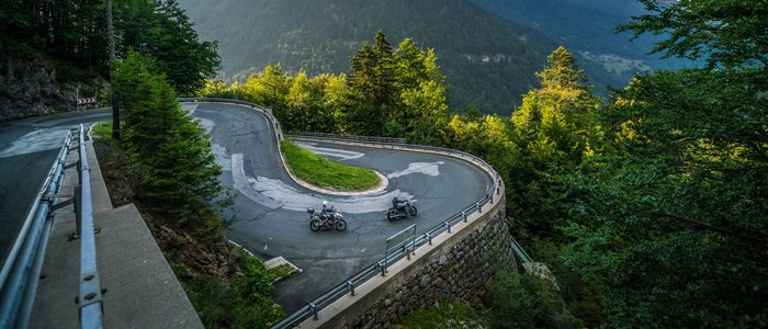 Enge Haarnadelkurve auf Bergstraße mit zwei Motorrädern