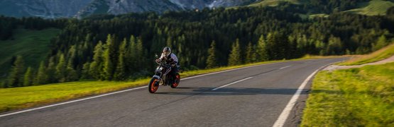 Motorradurlaub in der Region Hochkönig © Moppetfoto.de Motorradfahrer auf Bergstraße mit Bergen und Wald im Hintergrund