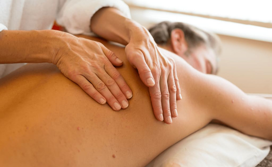 Person erhält entspannende Rückenmassage in hellem Raum