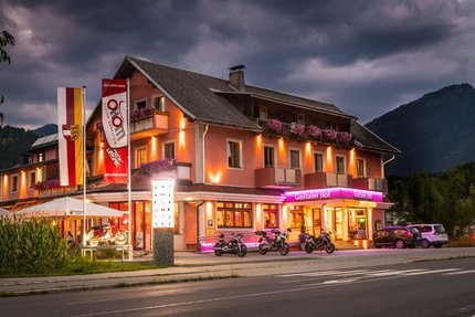 Gailtaler Hof © Moppetfoto.de Beleuchtetes Hotel mit Motorrädern und Autos bei Abenddämmerung