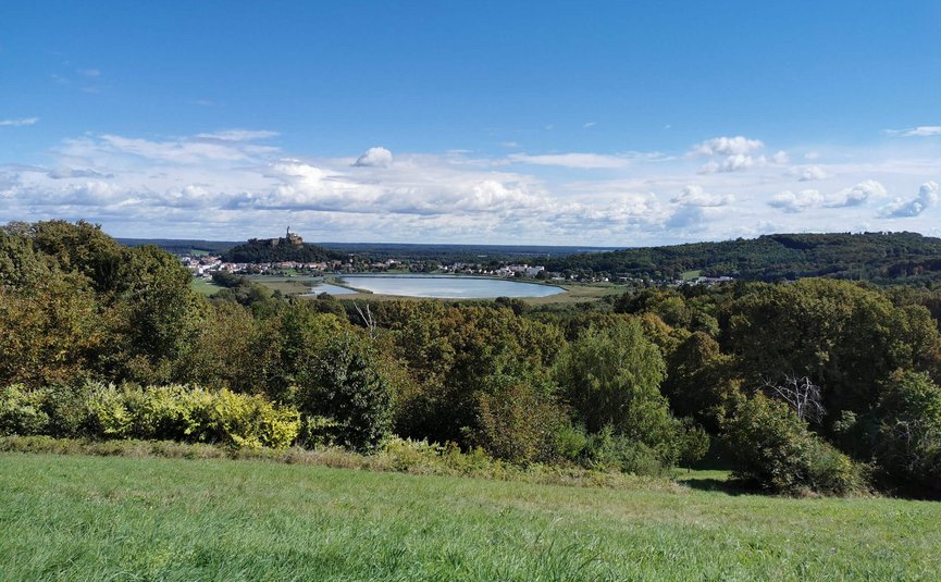 Motorradurlaub im Burgenland © Leberzipf Didi Blick auf eine grüne Landschaft mit einem See und einer Burg im Hintergrund