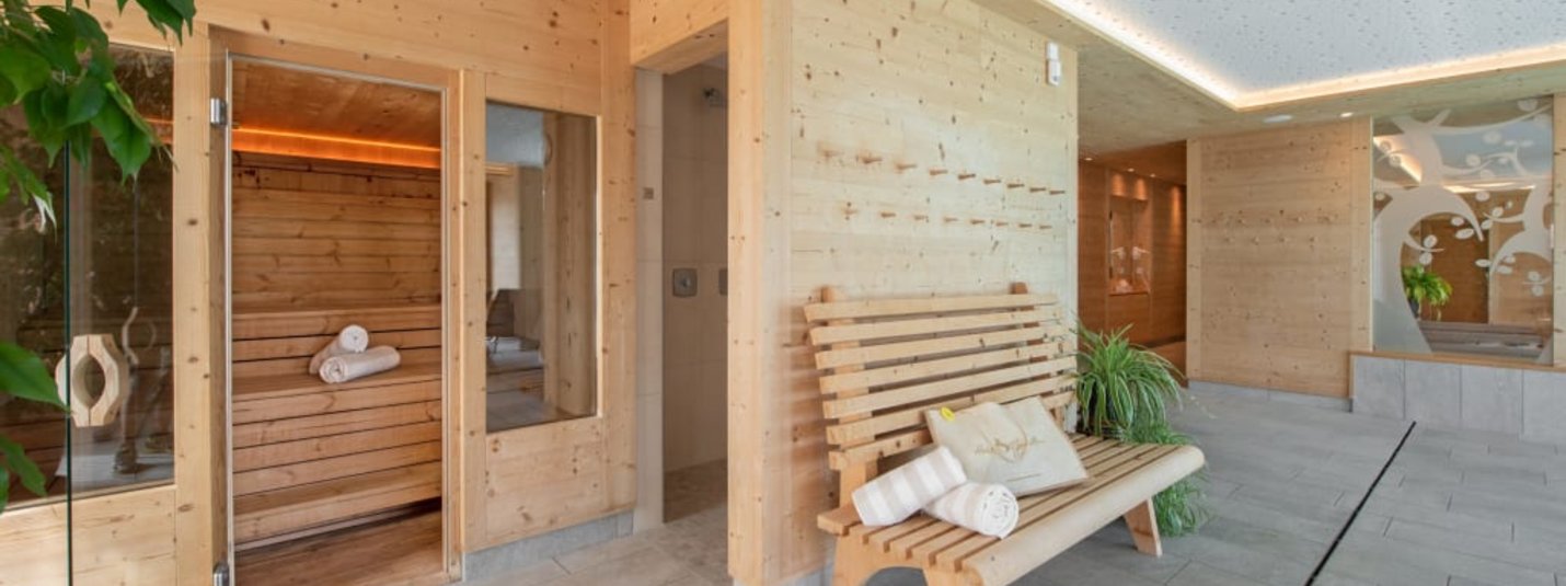 Winter Wellness Weekend 3 Nächte Saunabereich mit Holzwänden, Bank und Handtüchern in modernem Spa