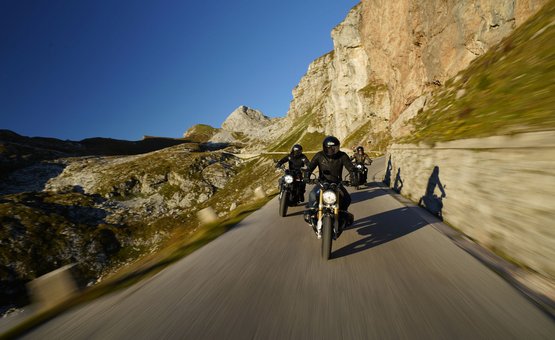 Motorradurlaub in Südkärnten – Karawanken – Slowenien © Jörg Künstle Drei Motorradfahrer fahren eine Bergstraße entlang unter klarem blauen Himmel