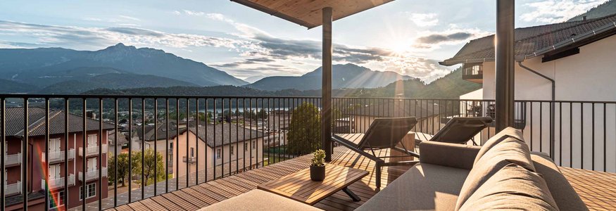 So geht Gravelbike-Urlaub im Hotel Cristallo
 © Andrea Acler Terrasse mit Sofa und Liegestühlen mit Bergblick bei Sonnenuntergang