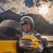 Willi Callies © Moppetfoto.de Mann auf gelbem Motorrad vor Berglandschaft bei Sonnenuntergang
