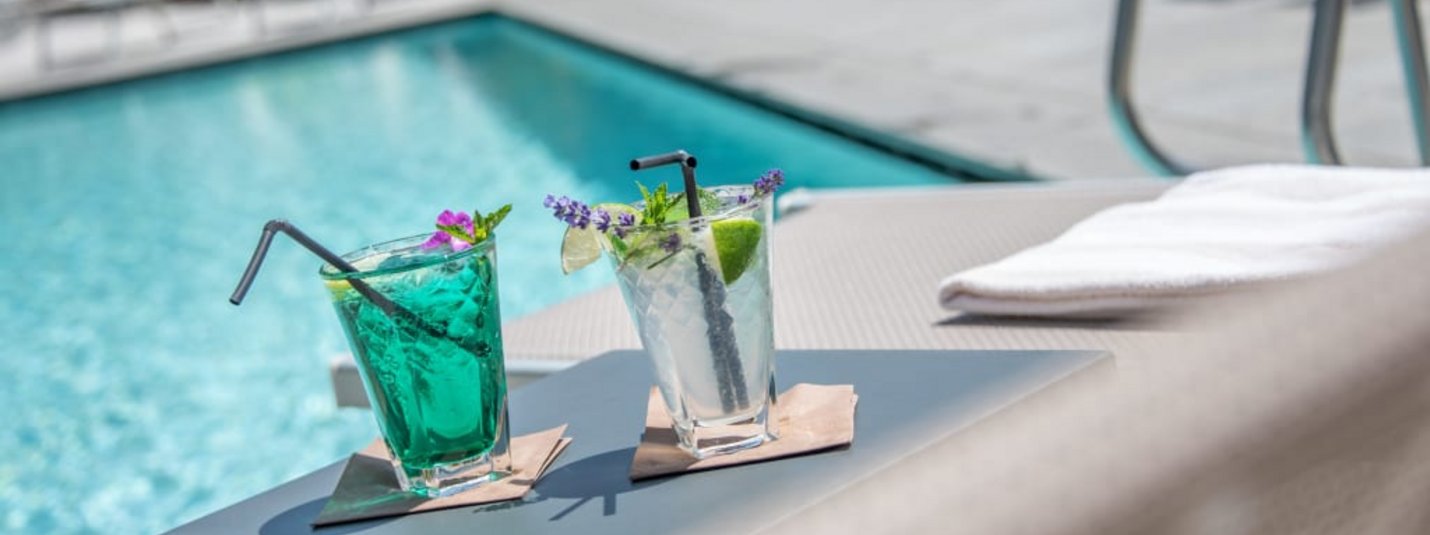 Wellness Weekend 3 Tage Zwei Cocktails auf einem Tisch neben einem Pool im Freien