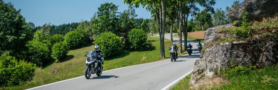 Motorradurlaub im Mühlviertel © Moppetfoto.de Motorradfahrer auf einer ländlichen Straße mit Bäumen und Felsen