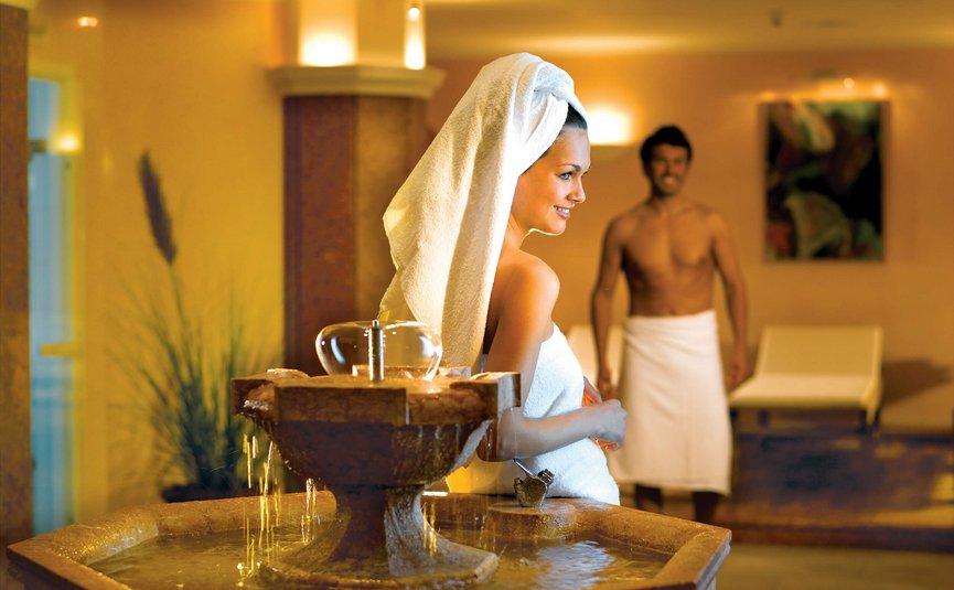 Frau und Mann in Handtüchern in einem Spa-Raum mit einem Brunnen