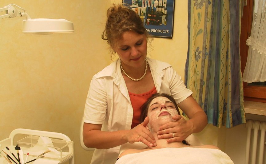 Hotel Bergblick © Hotel Bergblick Kosmetikerin massiert Gesicht einer Frau mit Gesichtsmaske im Behandlungsraum