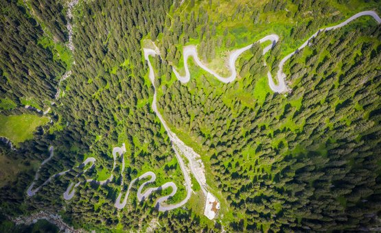 Motorradurlaub am Arlberg – Dreiländereck © Moppetfoto.de Serpentinenstraße durch dichten Wald aus der Vogelperspektive