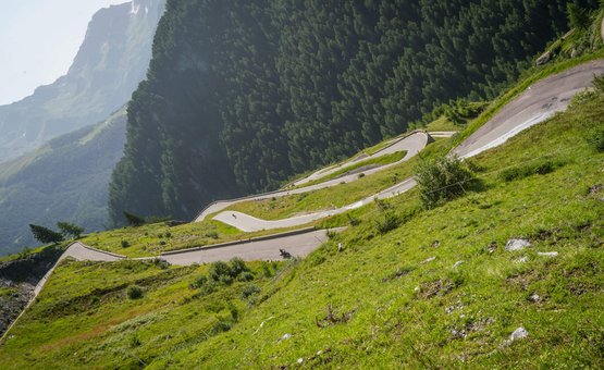 Motorradurlaub im Ötztal – Timmelsjoch © Moppetfoto.de Serpentinenstraße zwischen grünen Bergen unter klarem Himmel