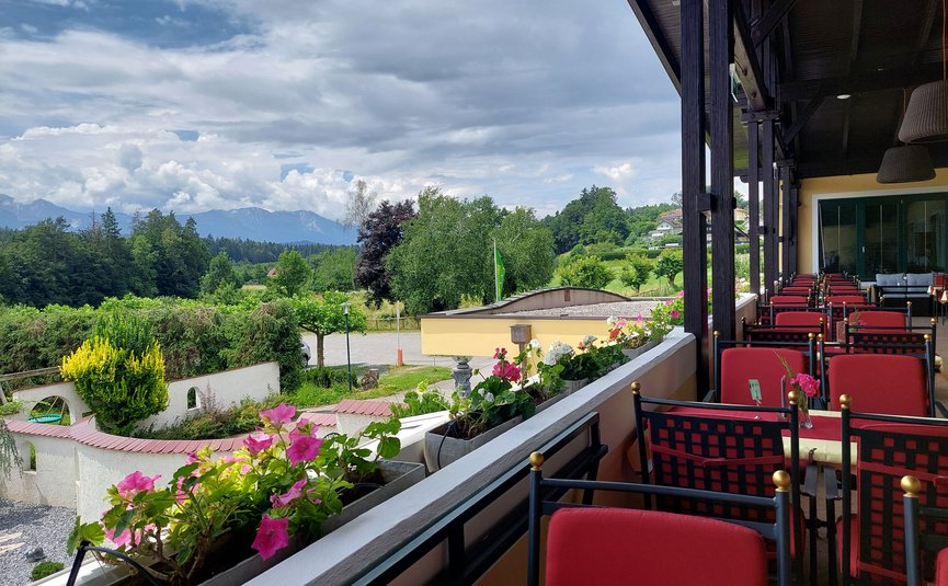 Hotel Marienhof – mein Refugium **** © Bianca Wagner Balkon mit roten Stühlen und Blumen mit Blick auf grüne Landschaft und Berge