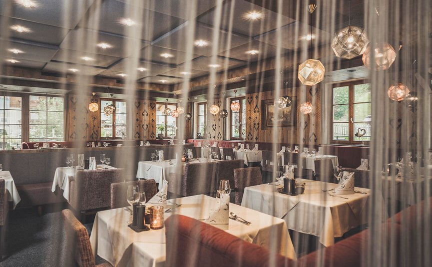 Elegantes Restaurant mit gedeckten Tischen und modernen Lampen