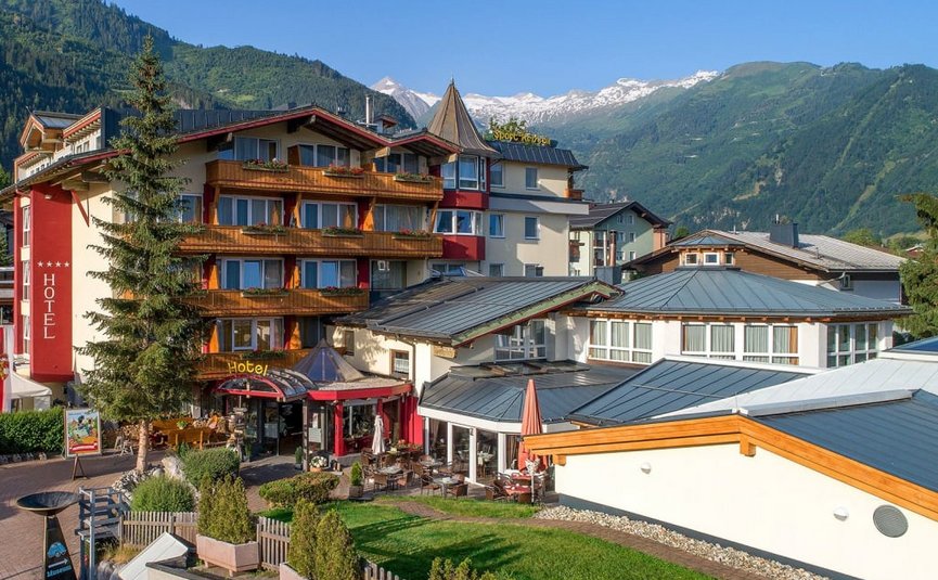 Sternfahrt Motorrad-Special ab € 598,- pro Person Hotelgebäude an einem sonnigen Tag mit Bergen im Hintergrund