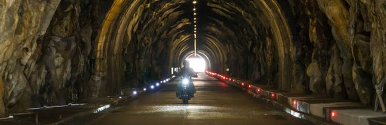 Motorradurlaub im Ötztal – Timmelsjoch © Moppetfoto.de Motorradfahrer fährt durch beleuchteten Felsentunnel