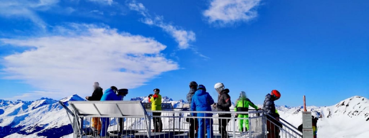 Schneekristallwochen Aussichtsplattform mit Menschen und verschneiten Bergen bei klarem Himmel