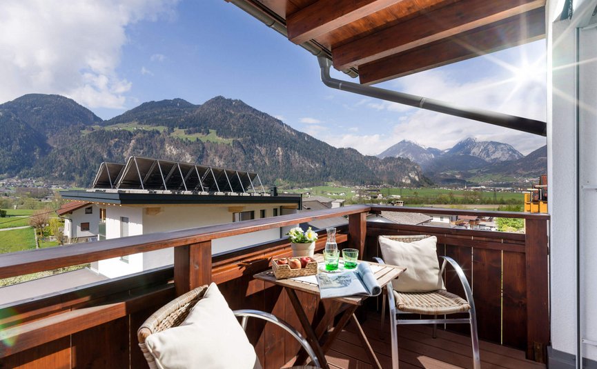 Balkon mit Stühlen, Tisch und Bergblick bei sonnigem Wetter