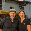 zwei lächelnde personen vor hotel mit motorrädern im hintergrund
