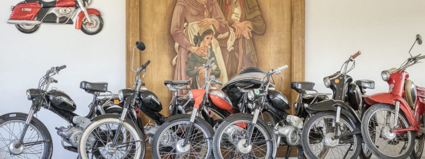 🛵2-Wheeler-Midweek🏍️ Sammlung alter Motorräder vor einem Wandbild mit einer Familie