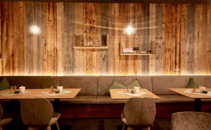 Gemütlicher Sitzbereich mit Holzverkleidung und sanfter Beleuchtung in Café