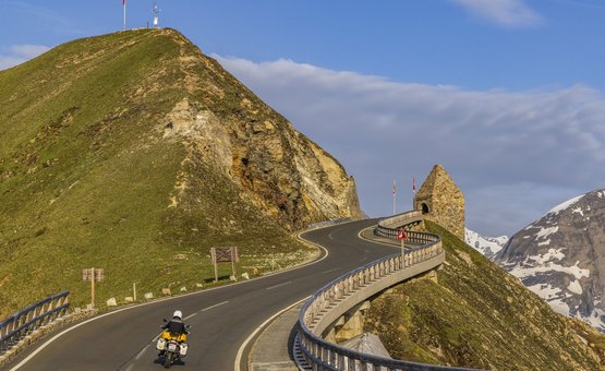 Motorradurlaub im Mölltal – Großglockner – Nockalm © Alexander Seger Motorradfahrer auf kurviger Bergstraße mit Aussicht auf schneebedeckte Gipfel