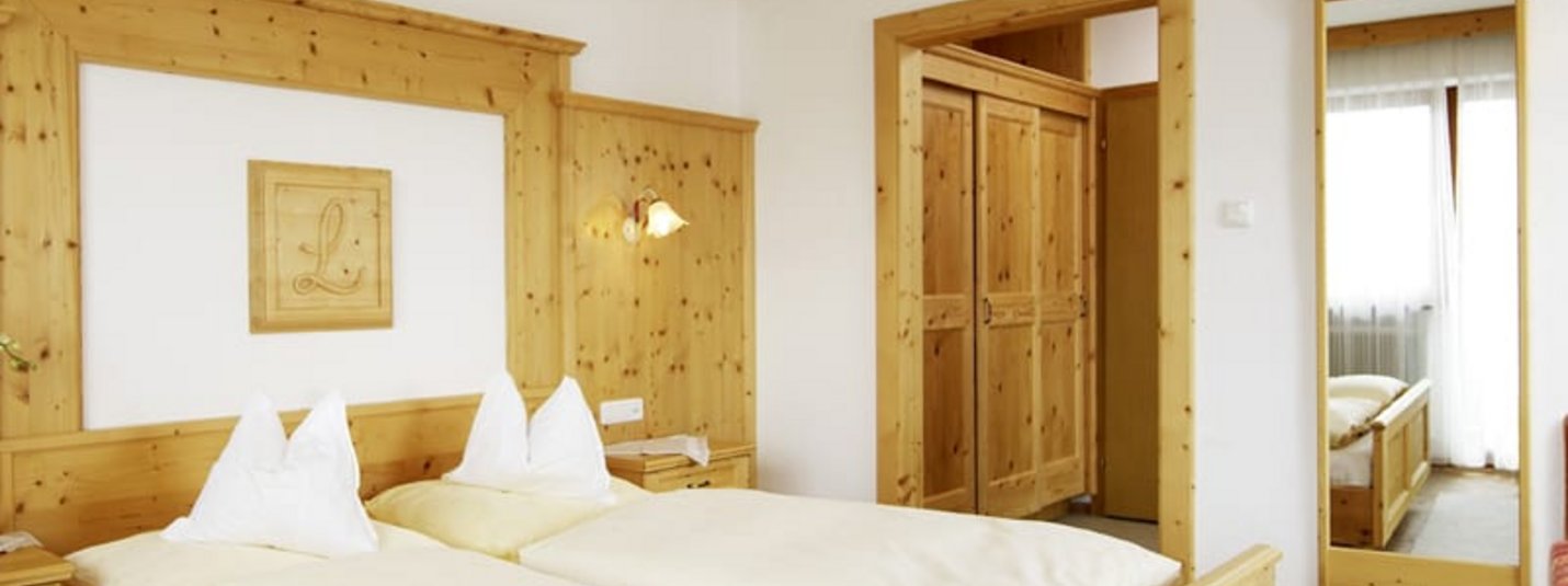 Firn Schnee Pauschale Hell eingerichtetes Schlafzimmer mit Holzmöbeln und Doppelbett