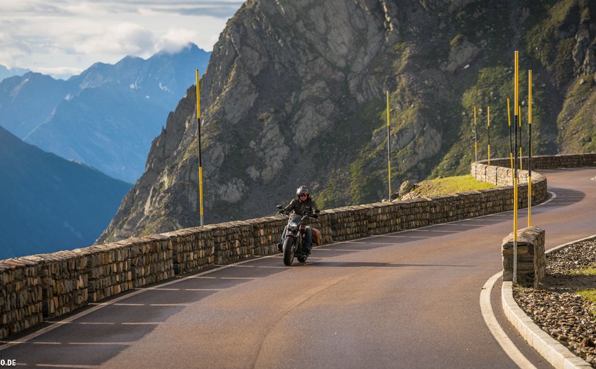 Alpenhotel Laurin ***S © Moppetfoto.de Motorradfahrer auf kurvenreicher Bergstraße mit Steinmauer und Bergen im Hintergrund