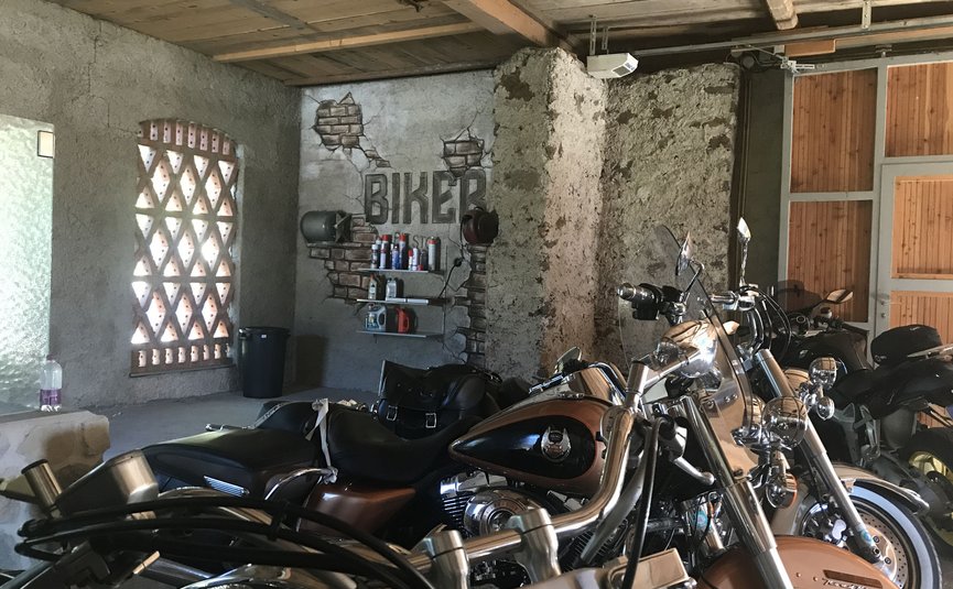 Motorräder in einer Garage mit Betonwänden und Holzdecke