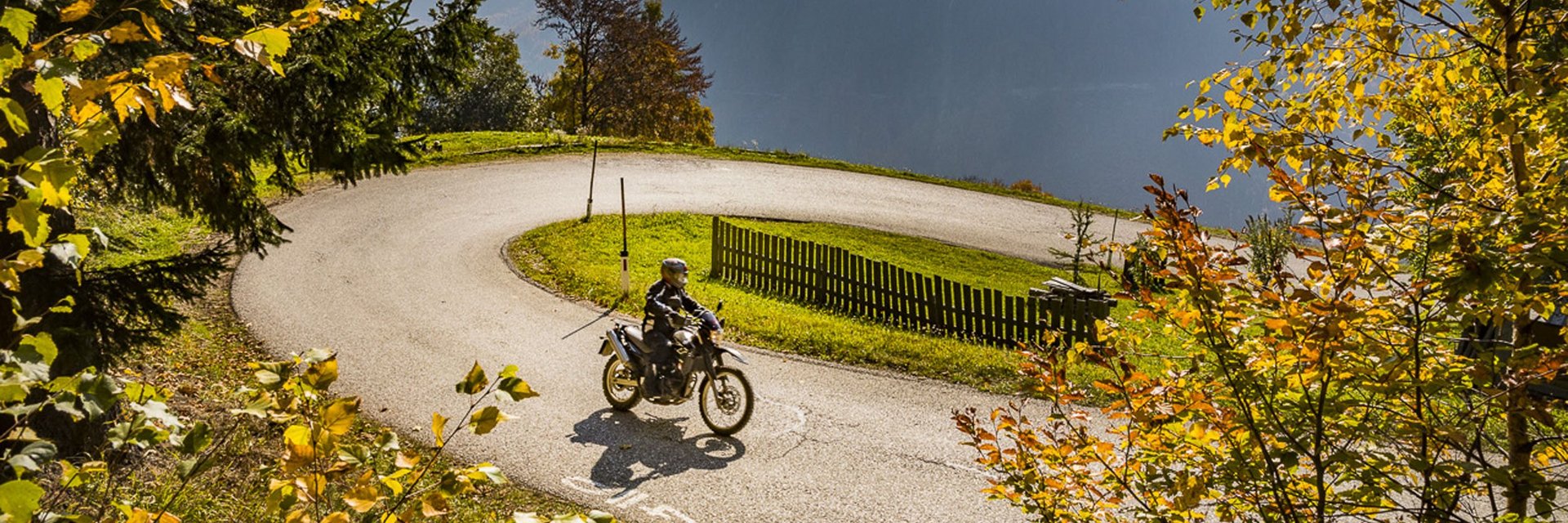Hotel Marienhof – mein Refugium **** © Alexander Seger Motorradfahrer fährt durch eine kurvige Straße im herbstlichen Bergwald