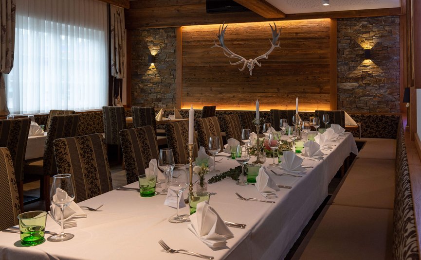 Eleganter Esstisch in einem rustikalen Restaurant mit Hirschgeweih und Kerzen