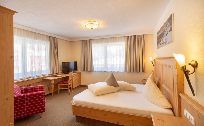 Gemütliches Hotelzimmer mit Holzmöbeln und Doppelbett