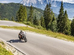 Obersteiermark – Ausseerland – Salzkammergut © Alexander Seger Motorradfahrer auf kurviger Bergstraße mit Tannen und Bergen im Hintergrund