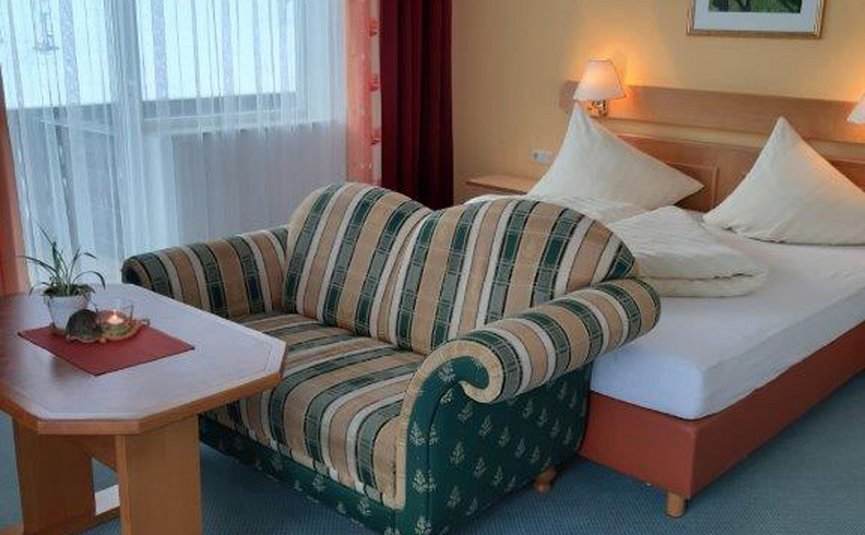 Gast-Hof-Laden Schneeweiss *** © Gast-Hof-Laden Schneeweiss Hotelzimmer mit Bett, Sofa, Tisch und Fenster mit Vorhängen