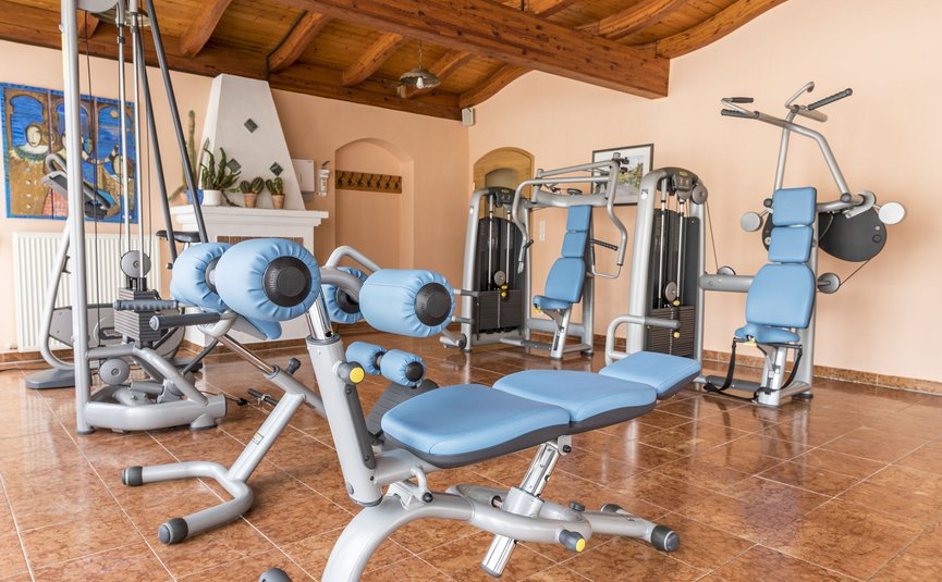 Hotel Marienhof – mein Refugium **** © Bianca Wagner Fitnessraum mit blauen Trainingsgeräten und Holzbalkendecke