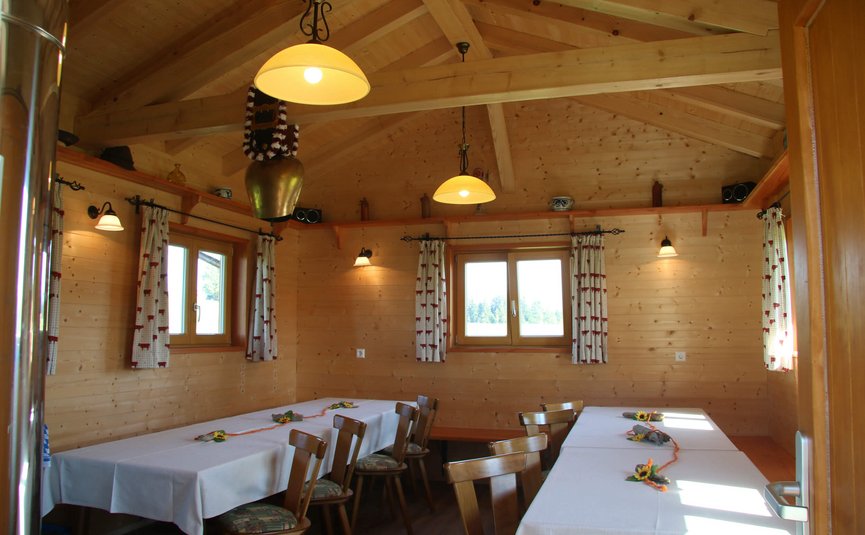 Hotel Bergblick © Hotel Bergblick Holzraum mit weißen Tischdecken und Holzstühlen