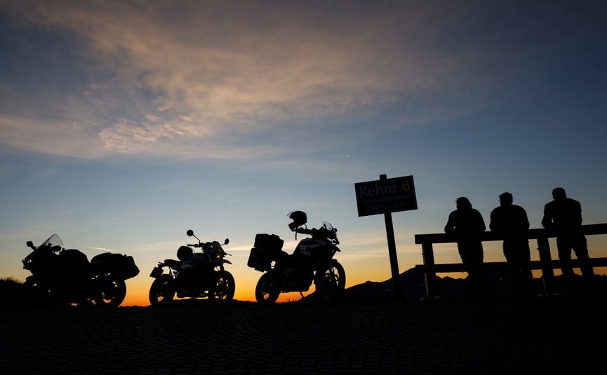 Sternfahrt Motorrad-Special ab € 598,- pro Person Sonnenuntergang mit Motorrädern und Menschen an einer Aussichtsplattform