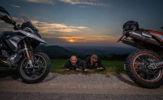 Motorradurlaub im Mühlviertel © Moppetfoto.de Zwei Männer liegen auf Gras zwischen Motorrädern bei Sonnenuntergang