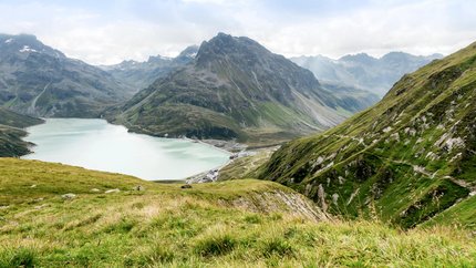 Paznaun – Silvretta © Montafon Tourismus GmbH - Andreas Haller Bergsee und grüne Alpenhänge bei bewölktem Himmel