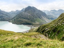 Paznaun – Silvretta © Montafon Tourismus GmbH - Andreas Haller Bergsee und grüne Alpenhänge bei bewölktem Himmel