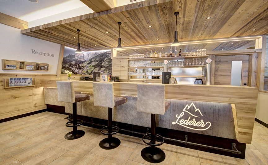 Modern gestalteter Hotelempfang mit Bar und Sitzhockern